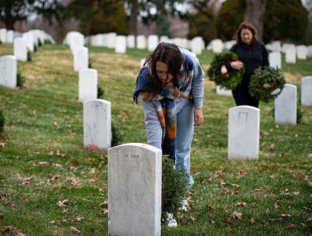 woman laying wreath at Arlington Cemetery