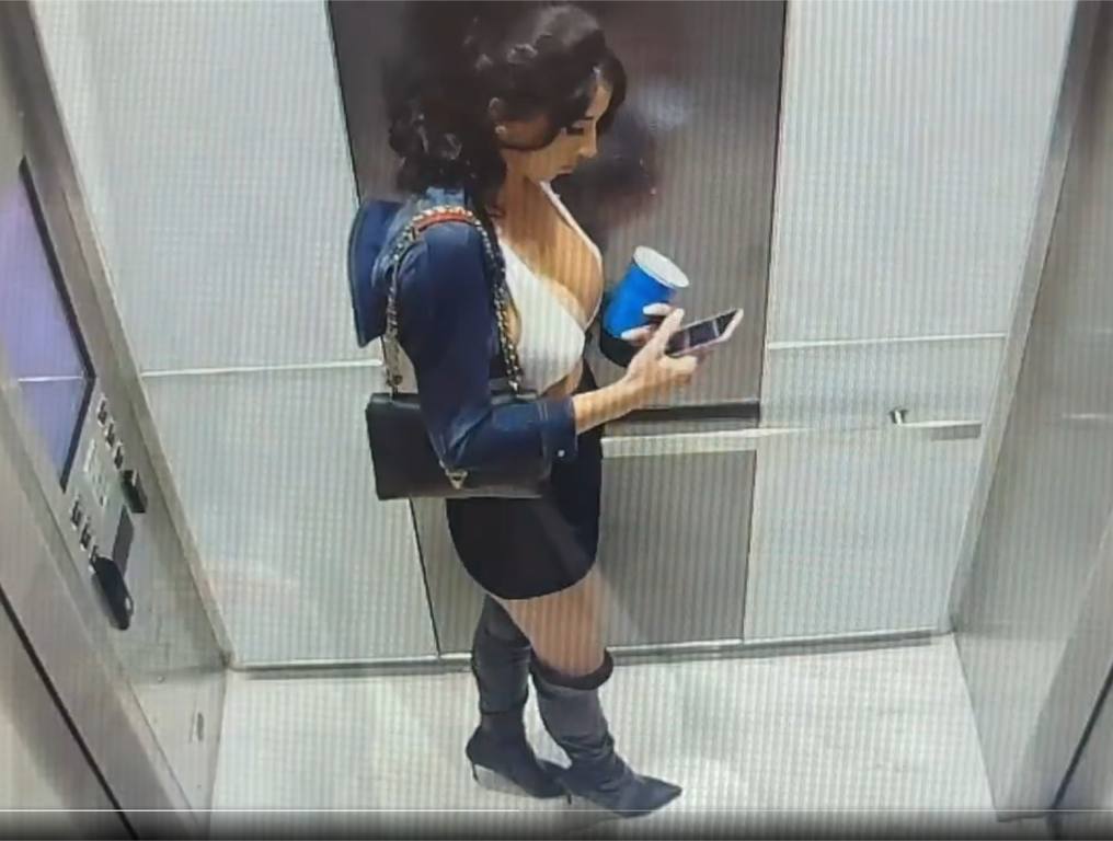 Florida Woman in elevator checking phone