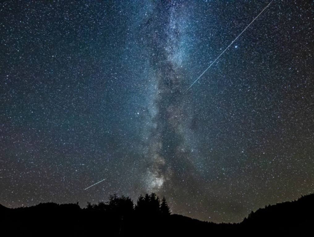 A shooting star crosses the sky like the milky way, meteor shower concept