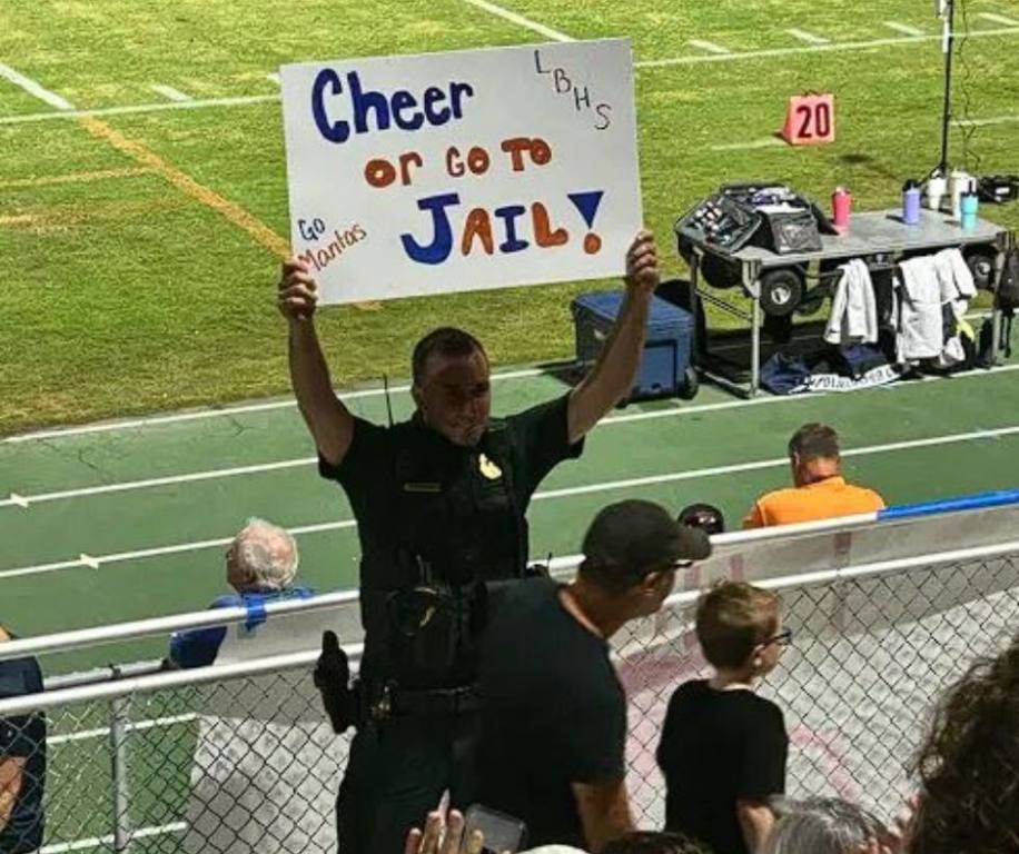 Deputy Farrands of Florida made a high school football game unforgettable by leading the crowd in cheers while holding a "cheer or go to jail" sign.