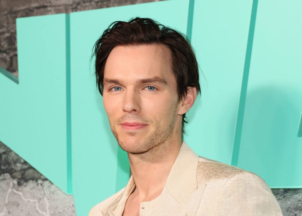 Nicholas Hoult attends the premiere of Universal Pictures' "Renfield" smiling wearing a light khaki blazer.