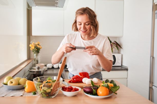 woman taking a photo of food she is preparing in the kitchen