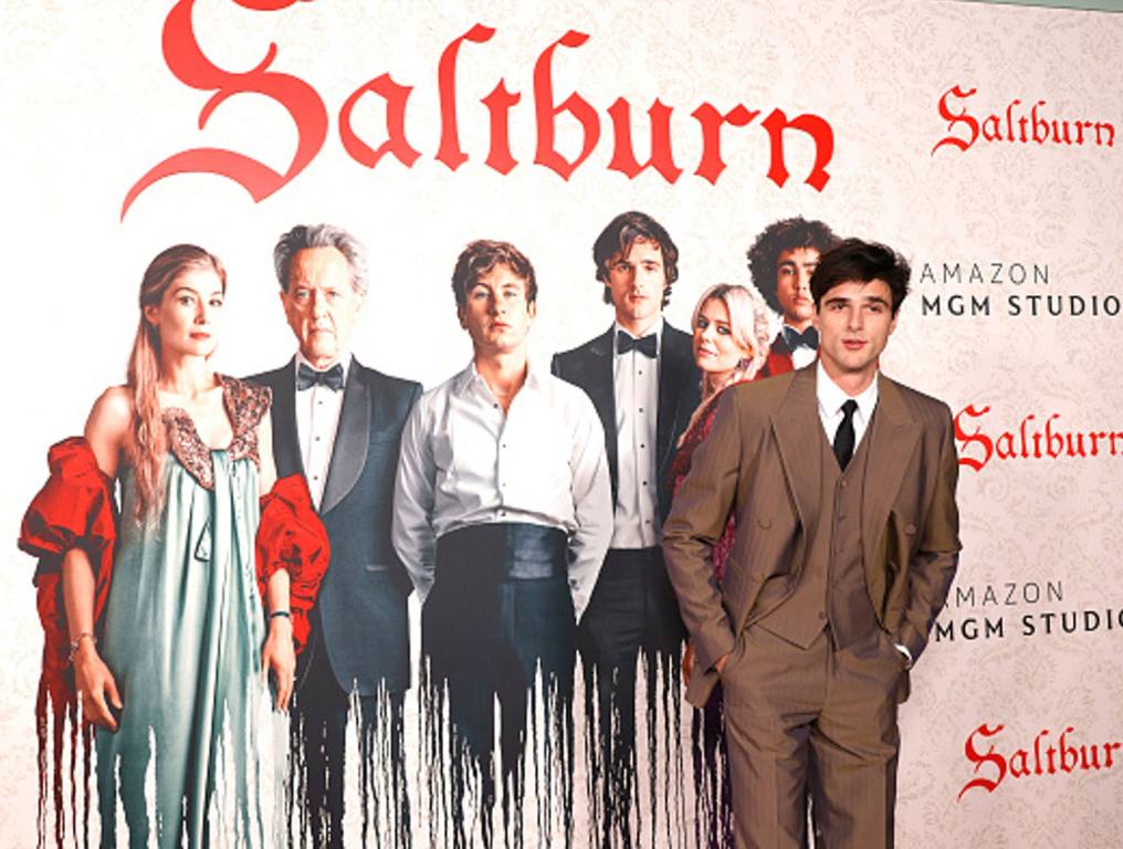 Jacob Elordi attends the Los Angeles Premiere Of MGM's "Saltburn" at The Theatre at Ace Hotel on November 14, 2023 infront of movie poster.