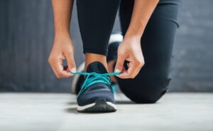 Female runner tying her shoes preparing for a run