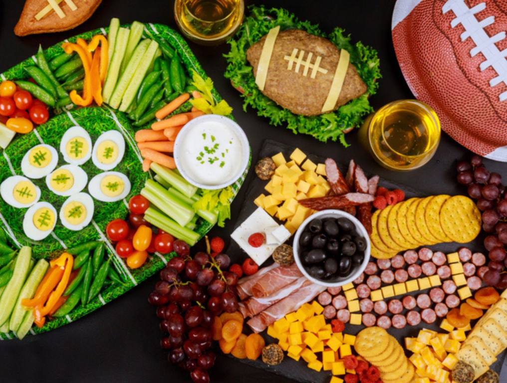 Party table with food and drink for watching American football game.