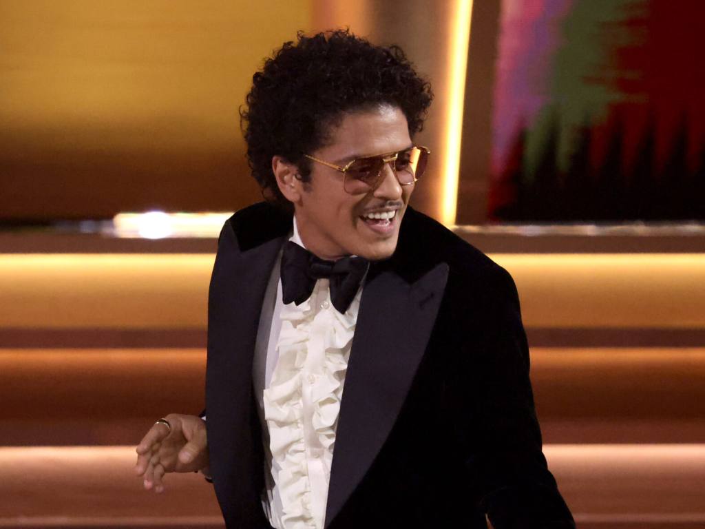 Bruno Mars of Silk Sonic accepts Song Of The Year for ‘Leave The Door Open’ onstage during the 64th Annual GRAMMY Awards, smiling looking to the right wearing a suit and bowtie, MGM Resorts Shuts Down Claims Bruno Mars Owes $50 Million in Gambling Debt.