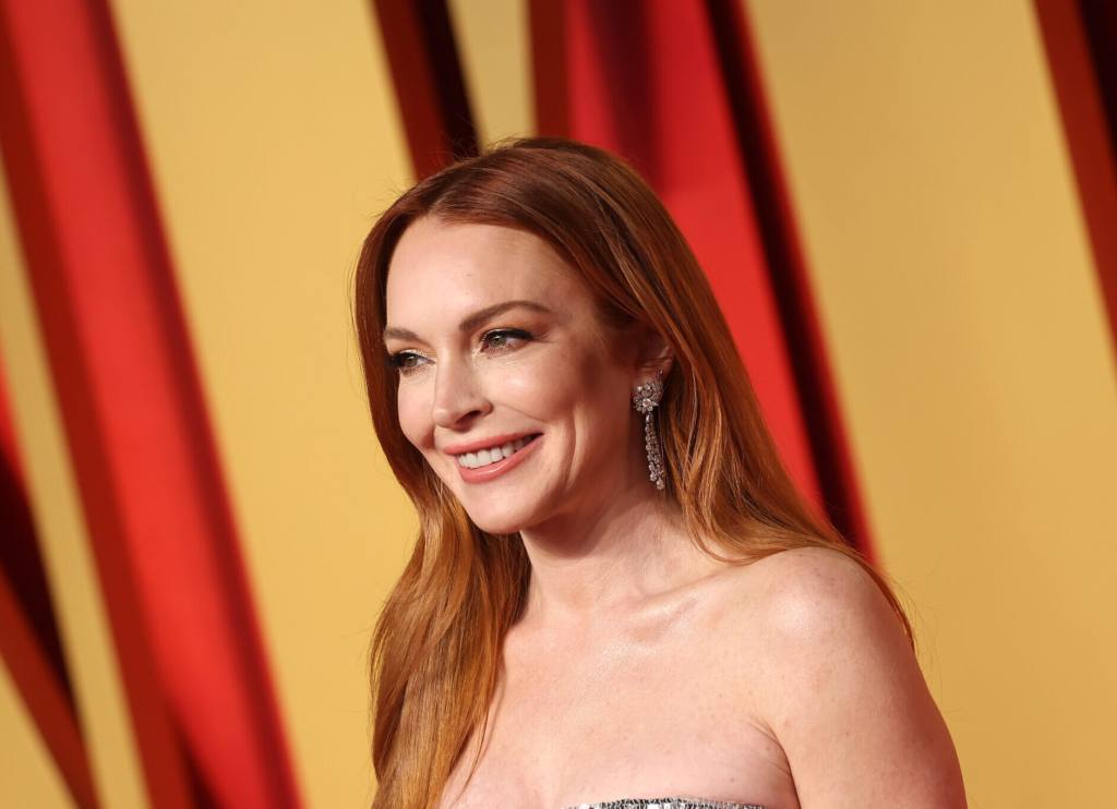 Lindsay Lohan attends the 2024 Vanity Fair Oscar Party smiling facing left wearing a strapless gown, Lindsay Lohan Feels No Rush To 'Snap Back' After Son's Birth.