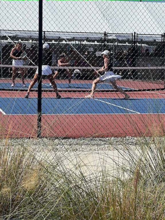 Two women in action, playing pickleball