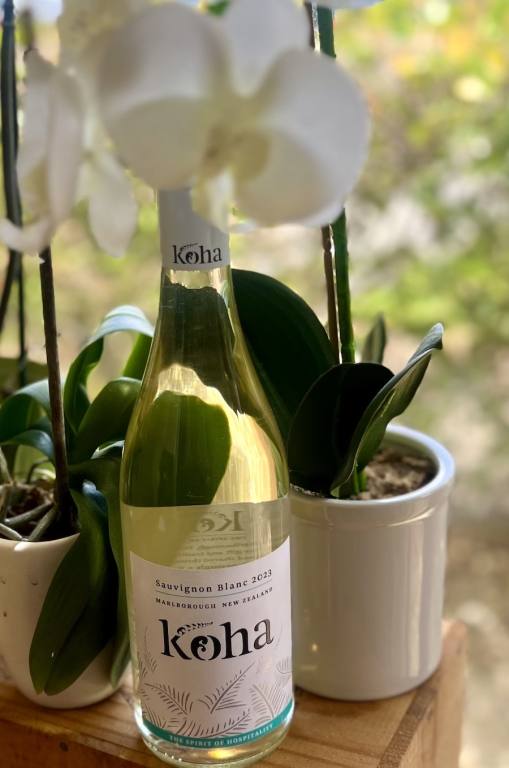 Bottle of Koha Marlborough Sauvignon Blanc next to white orchids