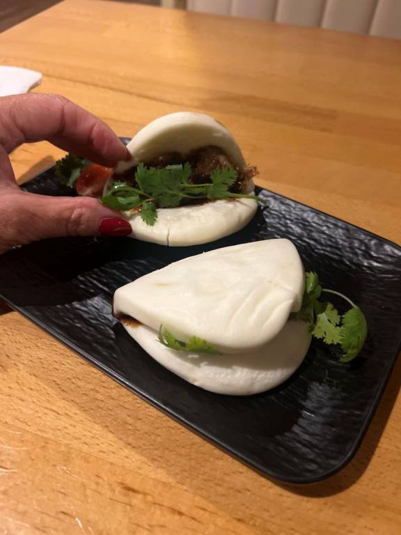 two small white buns with meat and green herbs