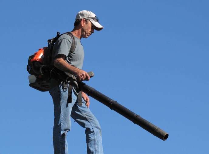 man weilding one of those backpack style noisy leaf blowers