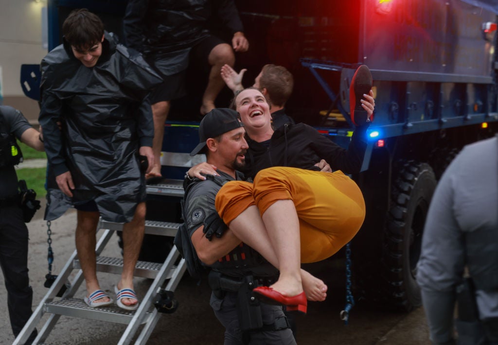 A City of Hollywood SWAT team member helps Alex Treacy from a search and rescue truck as she is evacuated from a flooded area on June 12, 2024, in Hollywood, Florida. As tropical moisture passes through the area, areas have become flooded due to the heavy rain.