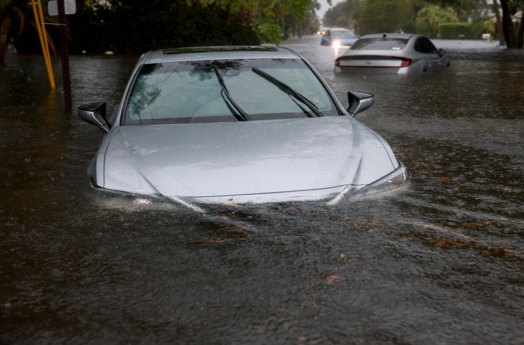 A vehicle sits in flood waters on June 12, 2024, in Hollywood, Florida. As tropical moisture passes through the area, areas have become flooded due to the heavy rain.