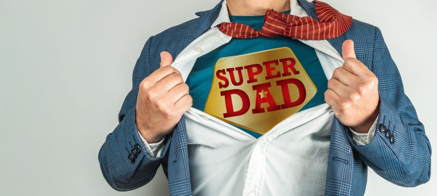 Man's hands pulling open a white dress shirt to reveal a superhero style shirt underneath. It reads Super Dad...for Fathers Day in Southwest Florida