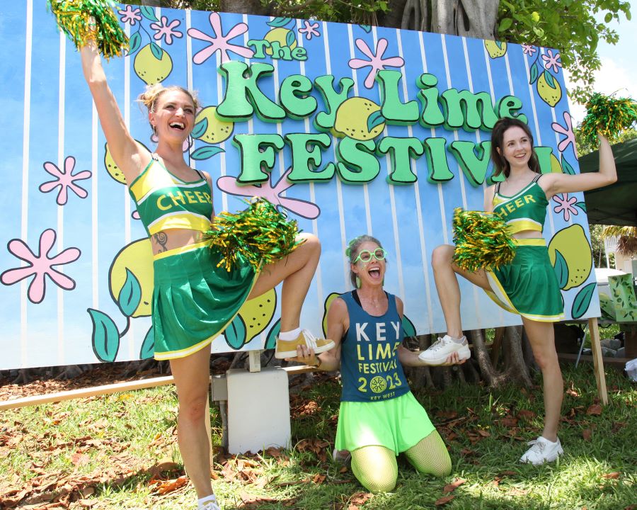 Cheerleaders dressed in green with green pompoms celebrating Key West Lime Festival