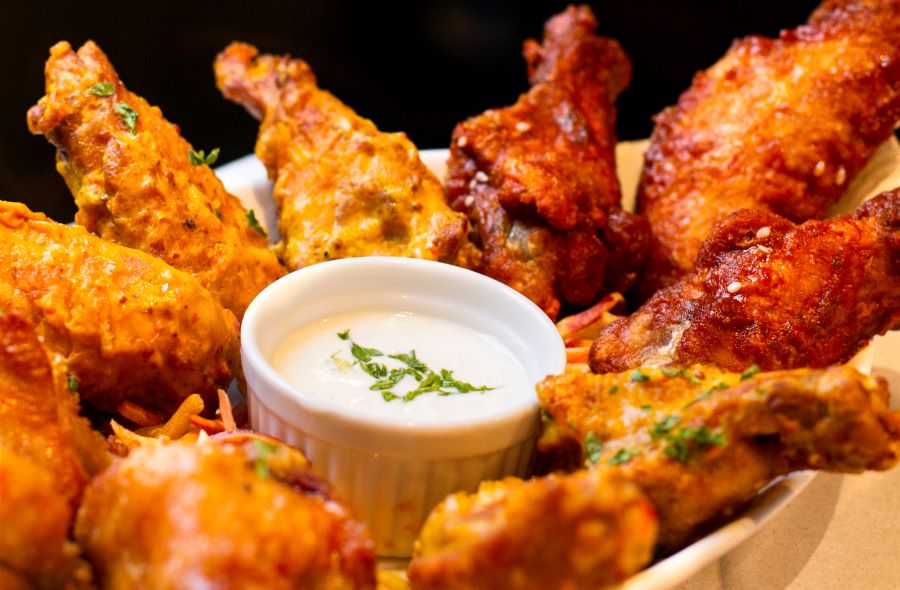 Plate of chicken wings with dressing in the middle for dipping, National Chicken Wing Day Deals in Southwest Florida