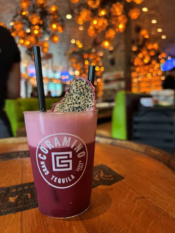 Dark pink cocktail with light pink froth in a bar glass