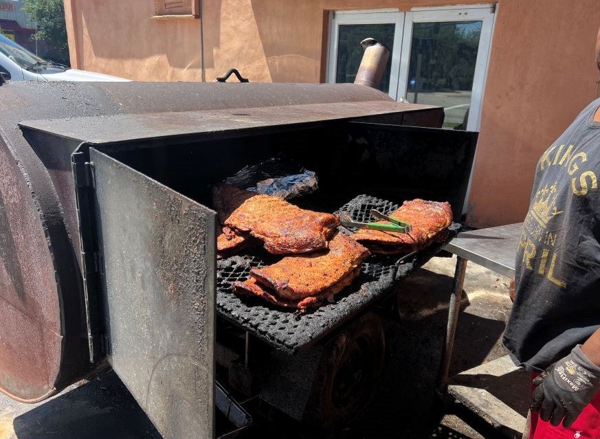 Smoker grill full of slabs of meat