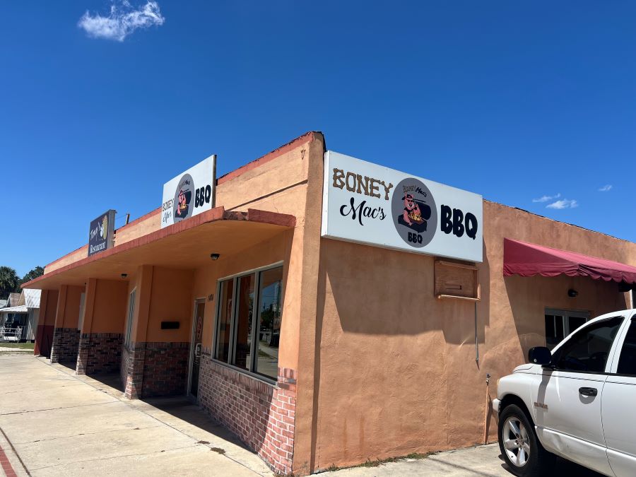 Corner view of Boney Mac's BBQ, a non-descript concrete building with small signage