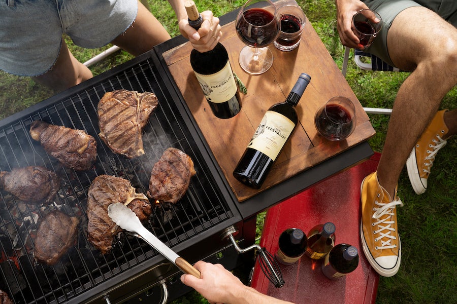 Burgers on the grill and bottles of The Federalist red wine for sips for National Red Wine Day and Labor Day