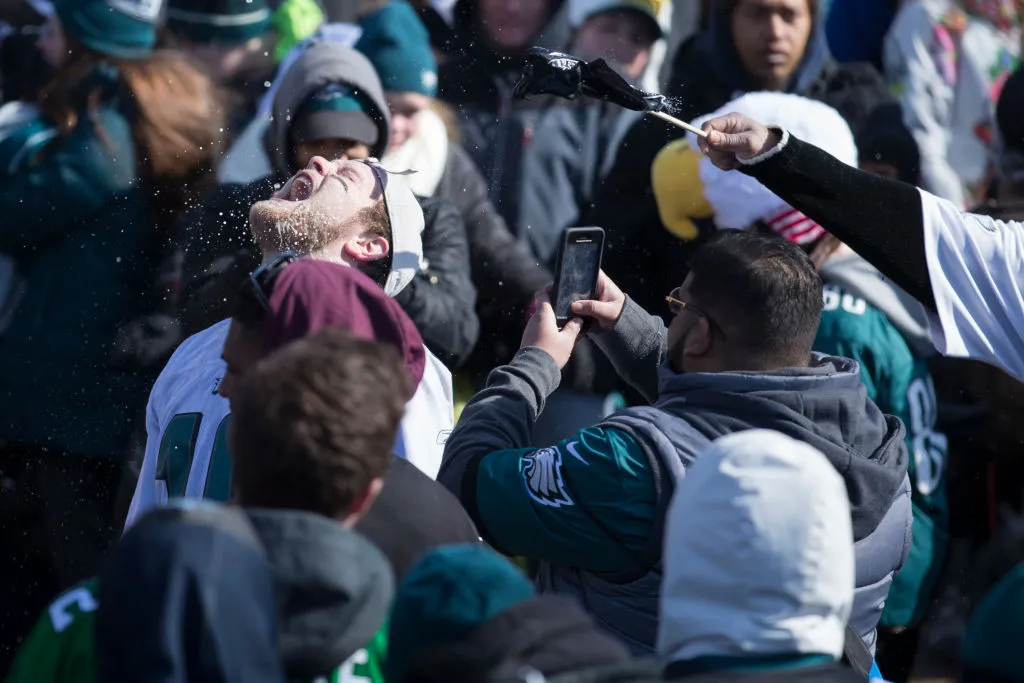 A Philadelphia Eagles fan has beer poured on him.