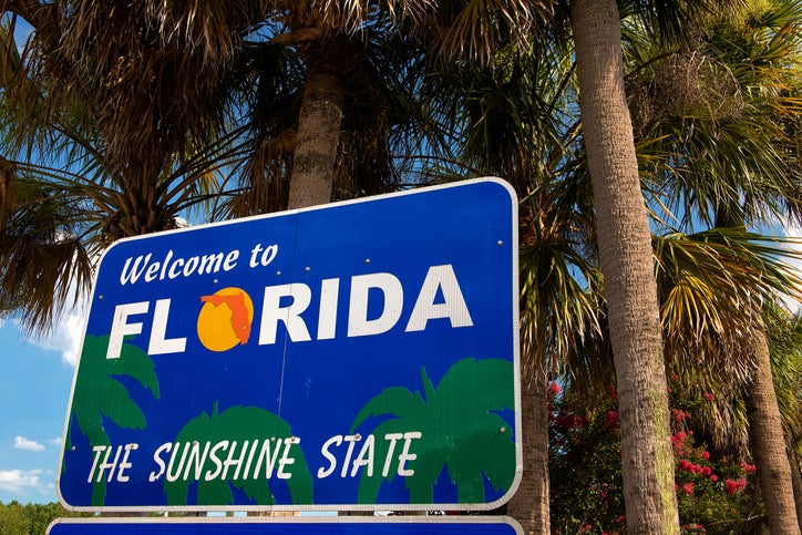 Welcome to Florida sign with palm trees in background as 2 Florida cities make best road trip list