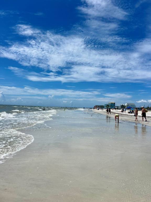 View of water line at the beach, blue sky, water rolling in