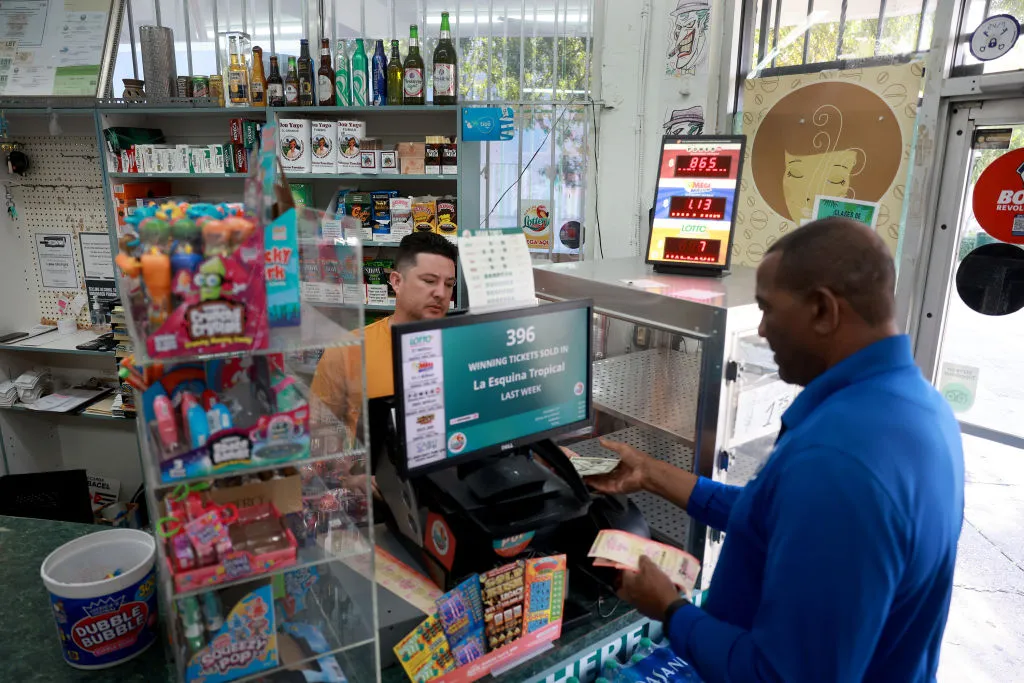 Frank Palacios purchases a Mega Million lottery ticket from Karl Lopez at the La Esquina Tropical supermarket in Miami, Florida. Here's to hoping he has the luckiest Mega Millions numbers