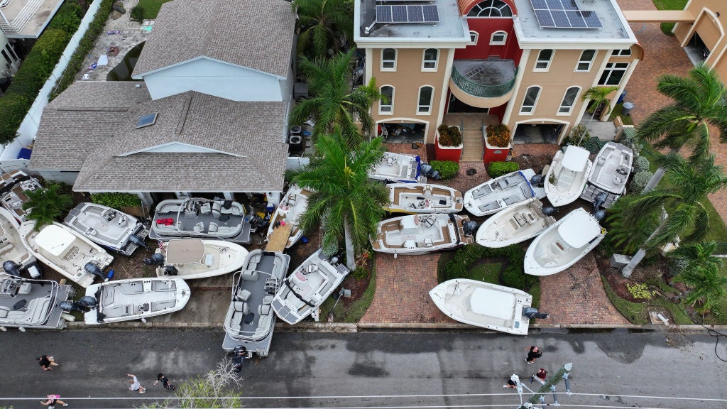 In this aerial view, boats are piled up in front of homes after Hurricane Helene hit the area as it passed offshore on September 28, 2024 in Treasure Island, Florida. Hurricane Helene made landfall Thursday night in Florida's Big Bend with winds up to 140 mph and storm surges that killed at least 42 people in several states.