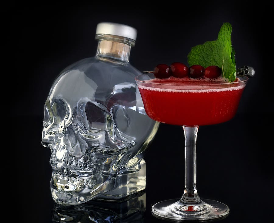 Bottle of crystal head vodka and a red cocktail for vodka for Halloween parties