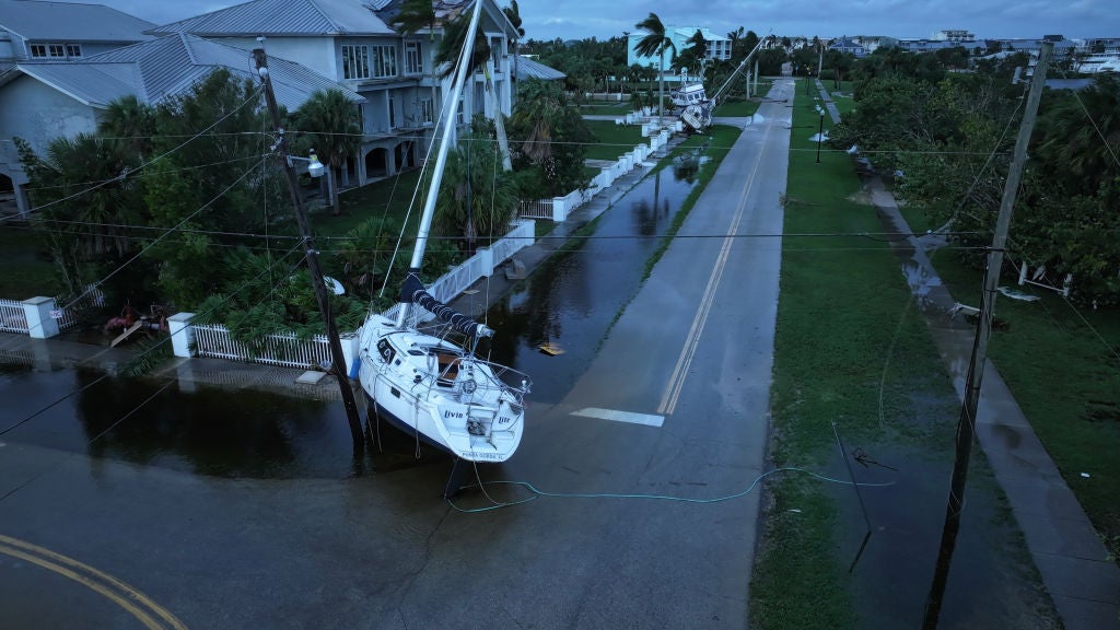 In this aerial view, a boat rests in a street after it was washed ashore when Hurricane Milton passed through the area on October 10, 2024, in Punta Gorda, Florida. The storm made landfall as a Category 3 hurricane in the Siesta Key area of Florida, causing damage and flooding throughout Central Florida.