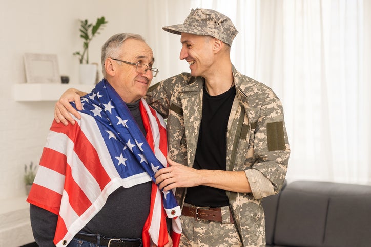 an elderly father and a military son, American flag.