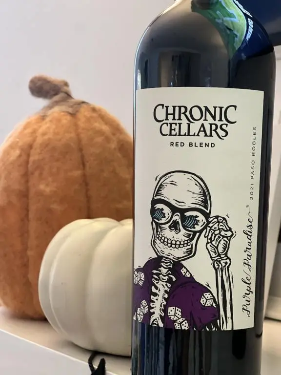 Bottle of Chronic Cellars Purple Paradise with pumpkins in the background for Halloween Themed Wines