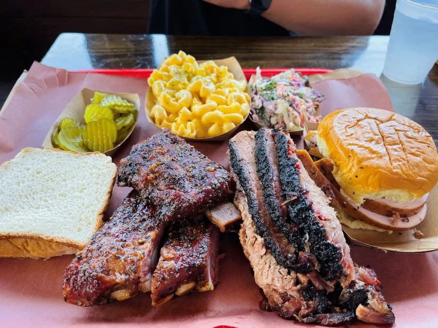tray with BBQ ribs, BBQ sandwich, macaroni and cheese and pickles found at the best bbq restaurants
