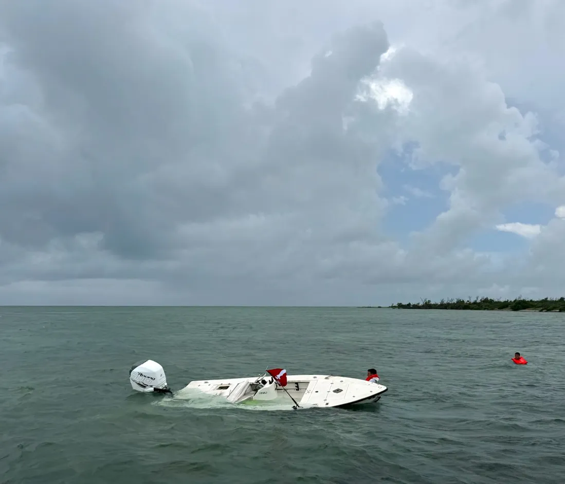 vessel taking on water and divers in the water