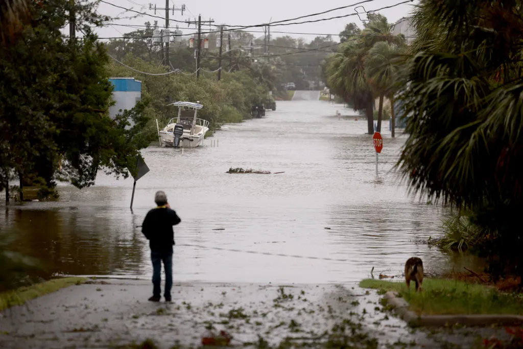 A person looks on at a flooded street caused by the rain and storm surge from Hurricane Debby on August 05, 2024, in Cedar Key, Florida. Hurricane Debby brings rain storms and high winds along Florida’s Big Bend area. 