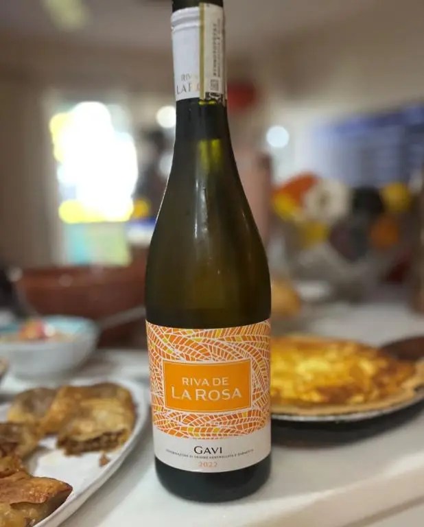 Bottle of wine with food in background, Aromatic White Wines For Thanksgiving